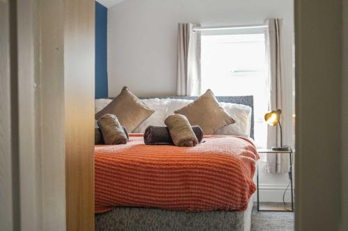 Un dormitorio con una cama con almohadas encima. en Cosy Home in Grimsby Town Centre, en Grimsby
