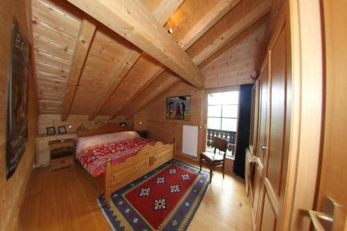 een slaapkamer met een bed en een houten plafond bij Tuschinski in Les Crosets