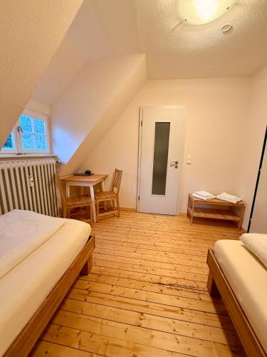 a attic room with two beds and a table at Gästehaus Malgarten in Bramsche