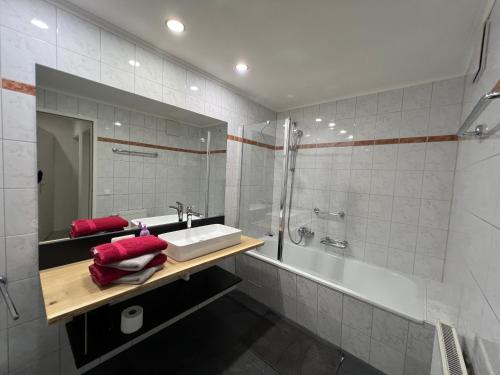 a bathroom with a sink and a shower and a tub at Schlossalm Appartement in Bad Hofgastein