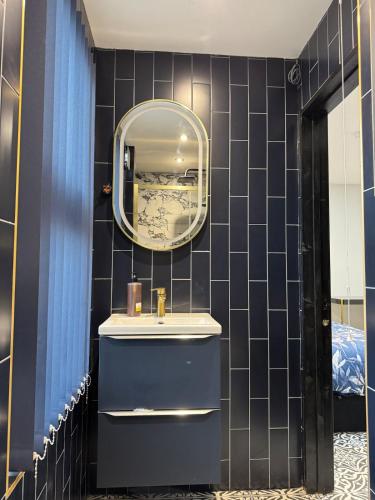 een badkamer met een wastafel en een spiegel bij Marble Black Deluxe in Gloucestershire