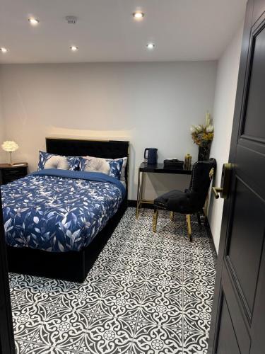 een slaapkamer met een bed, een bureau en een stoel bij Marble Black Deluxe in Gloucestershire