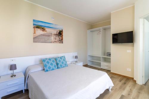 een slaapkamer met een bed en een flatscreen-tv bij Affittacamere Lumal in Domus de Maria