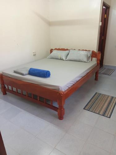 een bed met een blauw kussen op een kamer bij Amatamata in Malindi