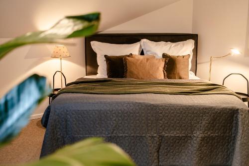 een slaapkamer met een groot bed met kussens bij HofZeit 1 in Mechernich