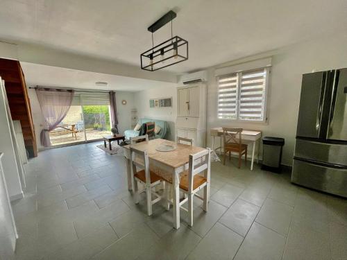 a kitchen with a table and chairs and a refrigerator at SERENITY Gite indépendant dans propriété avec piscine in Servian