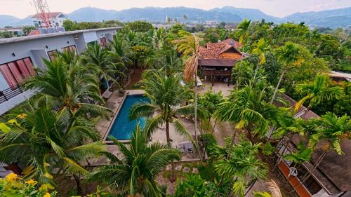 an aerial view of a resort with a pool and palm trees at Baan Phu Chalong Place in Ban Suan