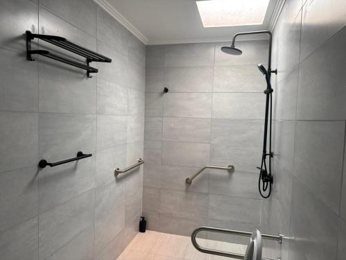 Un baño con ducha con puerta de cristal. en Hostal Mac, en Chillán