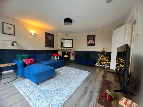 a living room with a blue couch and a christmas tree at Countryside Annexe in Felton