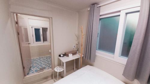 a bathroom with a shower and a sink and a mirror at 1971 Sinpung Inn in Seoul
