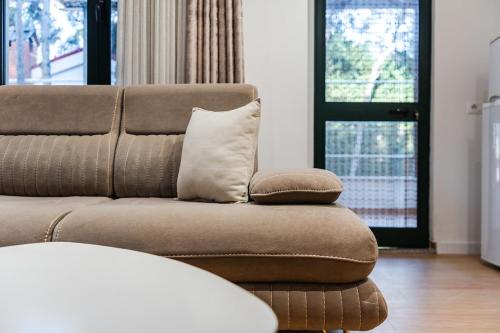 a couch with two pillows sitting in a living room at Pine & Sea Retreat in Golem