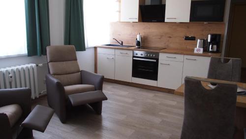 eine Küche mit einem Stuhl und einem Herd in der Unterkunft Pension Clara in Tanneberg