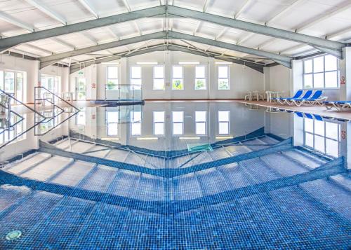 an empty swimming pool with blue tiles on the floor at Holywell Lodge in Newquay