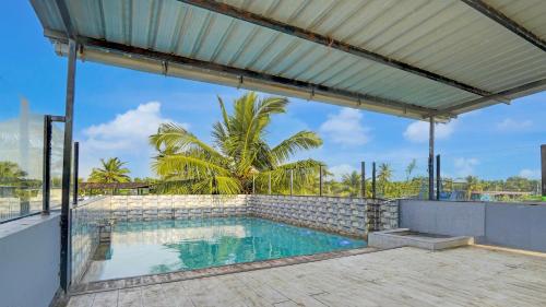 uitzicht op een zwembad vanaf de patio van een huis bij Hotel Beachfront - Couple & Family Friendly in Calangute