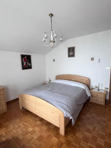 ein Schlafzimmer mit einem Bett und einem Kronleuchter in der Unterkunft Il Rifugio del Brunone in Valda