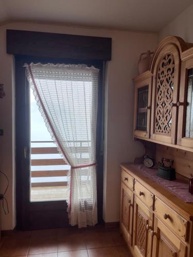 eine Küche mit einem Fenster und einem Holzschrank in der Unterkunft Il Rifugio del Brunone in Valda