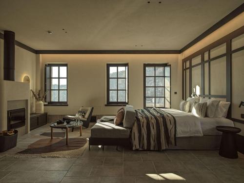 a bedroom with a large bed and a fireplace at Oreno Mountain Retreat Hotel in Tsepelovo