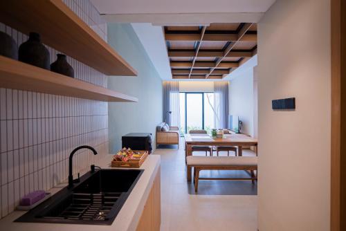 TimuranにあるAmani Suites Yogyakartaのシンク付きのキッチンとリビングルーム
