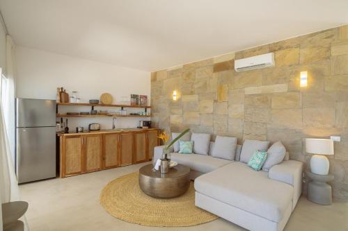 een woonkamer met een witte bank en een keuken bij Two Bedroom Beach Front Apartment with pool in Kiwengwa