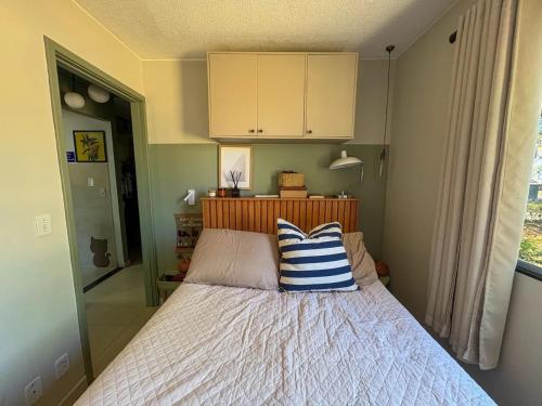 een slaapkamer met een bed met een blauw en wit kussen bij Jardins Mangueiral in Brasilia