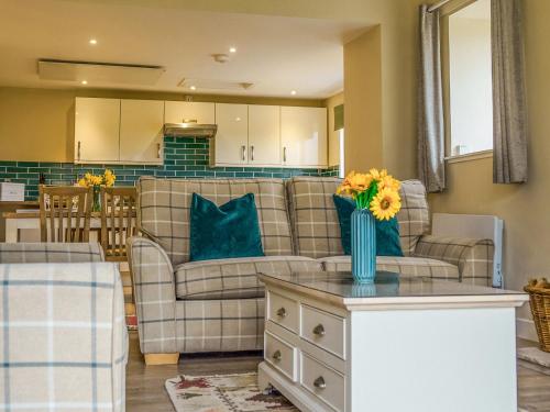 een woonkamer met een bank en een tafel met bloemen erop bij Dovecote - Uk47887 in Keilour