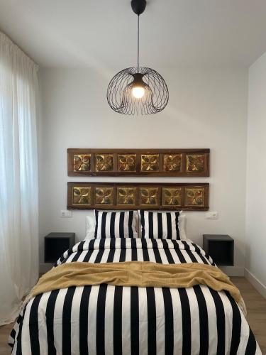 a bedroom with a bed with a black and white headboard at La Baltasara Apartments in Valladolid