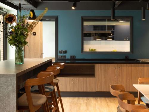 a kitchen with a counter with a vase of flowers at Adagio Antwerp City Center in Antwerp