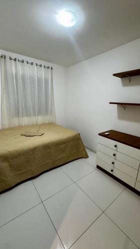a bedroom with a bed and a dresser in it at Apartamento VOG praia do Sul ilhéus in Ilhéus