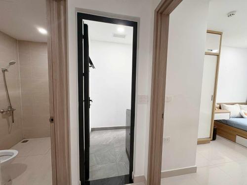 a bathroom with a glass door leading to a bedroom at Tom's House Apartment 1 in Thôn Văn Dương