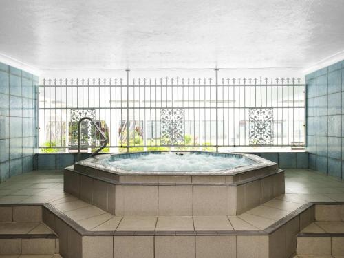 een hottub in een kamer met een raam bij BreakFree Beachpoint in Gold Coast