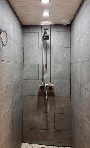 a shower stall with a shower head in a bathroom at Lahtihovi in Lahti