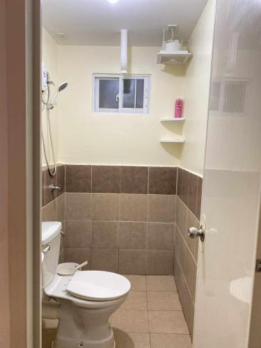 a bathroom with a toilet and a window at EasyStay Condo Davao in Davao City