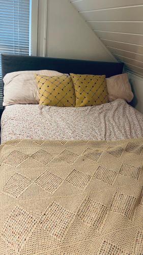 un letto con piumone e cuscini sopra di Solgården a Falkenberg