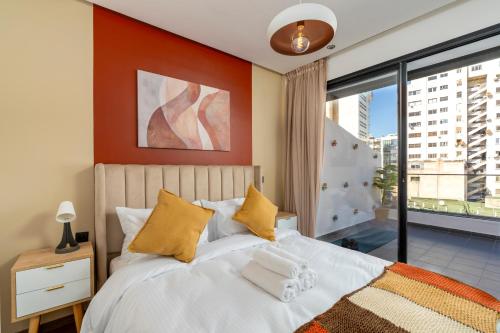 a bedroom with a bed and a large window at Bright Modern Studio, Gauthier in Casablanca