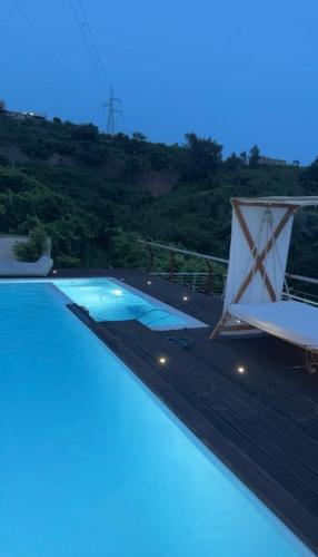 een zwembad 's nachts met een berg op de achtergrond bij Villa Ormalute in Pozzuoli