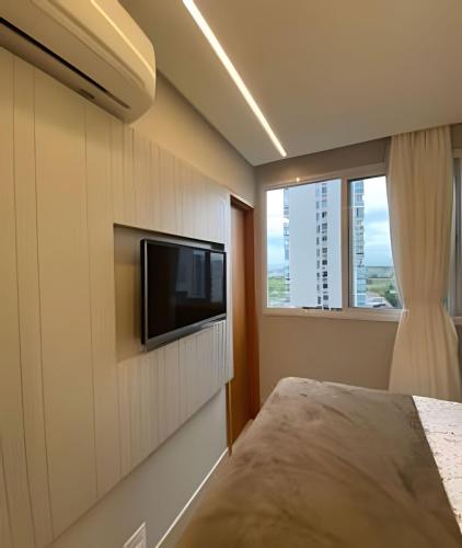 a bedroom with a flat screen tv on a wall at Itaparica Salinas Luxo in Itaparica