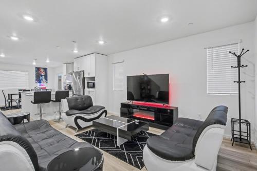 een woonkamer met zwart-wit meubilair en een tv bij Modern 2BR 2BA Townhome 15 Min to DEN in Commerce City