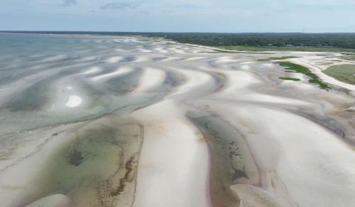 an aerial view of the sand and water on the beach at Steps to Bayside Beach Central AC Large Backyard in Brewster