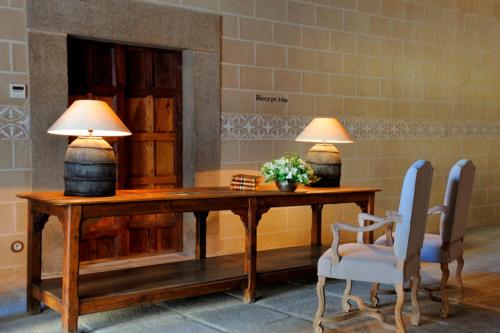 
a living room with a wooden table and chairs at Palacio Carvajal Girón in Plasencia
