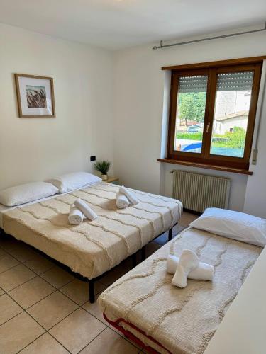 twee bedden in een kamer met handdoeken erop bij La finestra su Mori in Mori