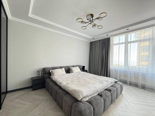 een slaapkamer met een groot bed in een witte kamer bij Kamanina Luxury Apartment in Odessa