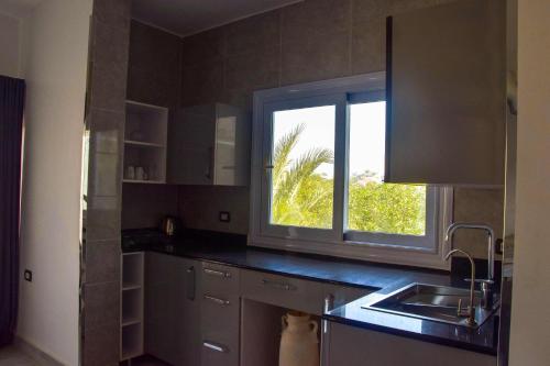 a kitchen with a sink and a window at Quiet Corner Apartment in Luxor