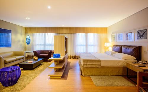 une chambre avec un lit et un salon dans l'établissement Iu-á Hotel, à Juazeiro do Norte