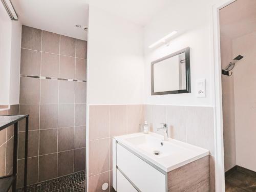 een badkamer met een wastafel en een spiegel bij La Ressource, Claire in Fontguenand