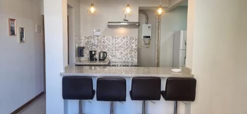 a kitchen with a counter with black chairs at O melhor de Terê in Teresópolis