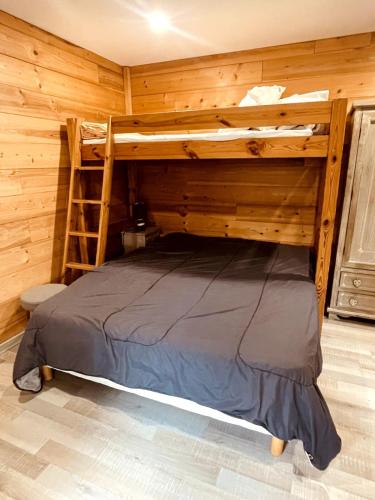a bedroom with a bunk bed in a log cabin at Studio cosy proximité télécabine ski Meribel - Cure thermale in Brides-les-Bains