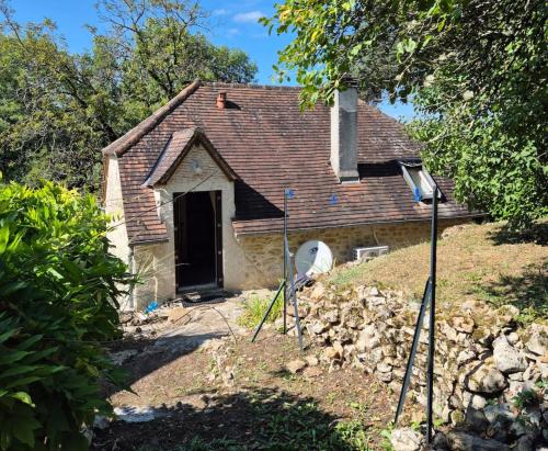une vieille maison avec des poteaux devant dans l'établissement La maison du bord de l'eau plage de baignade, à Vayrac