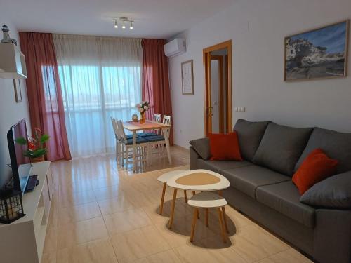 ein Wohnzimmer mit Sofa und Tisch in der Unterkunft Rincon de Almerimar Palm Beach Golf in Almerimar