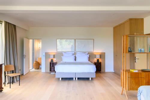 ein Schlafzimmer mit einem großen weißen Bett mit weißen Kissen in der Unterkunft Le Hameau des Sources Lourmarin Luberon in Apt