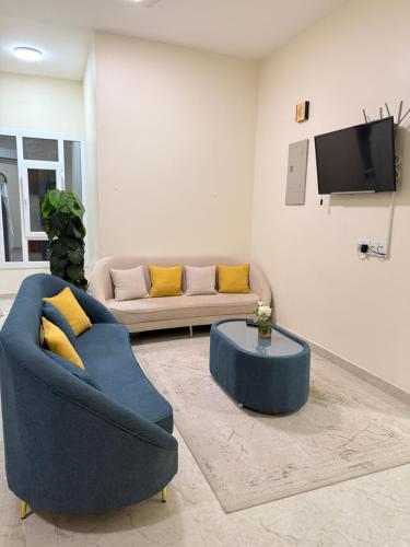 a living room with a blue couch and a table at mandegar guest house in Mawāliḩ